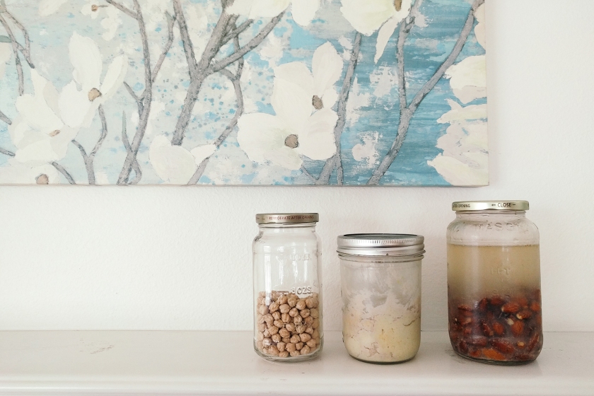 Cover photo with garbonzo beans, hummus, and soaked almonds, all in glass jars.